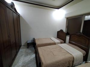 a small bedroom with two beds and a cabinet at زريقات للشقق المفروشه in Irbid