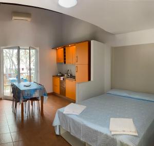 a bedroom with a bed and a table and a kitchen at Villini Frutteto in Castellaneta Marina 