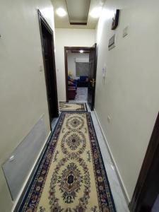 a hallway with a rug on the floor at زريقات للشقق المفروشه in Irbid
