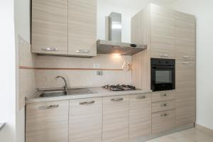uma cozinha com armários de madeira, um lavatório e um fogão em Casa Prataccio em Prataccio