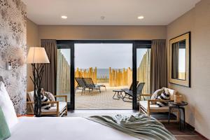 a bedroom with a bed and a view of the ocean at Beachhouse Hotel in Zandvoort