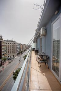 uma varanda com uma mesa e bancos num edifício em Socrates by Heloni Apartments em Atenas