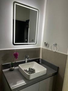 a bathroom with a sink with a mirror at Cozy Apartment w Terrace Near Cayala in Guatemala