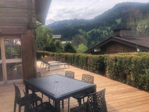 una mesa negra y sillas en una terraza de madera en Chalet Aravis, en Le Grand-Bornand 2 fotos más