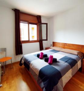 a bedroom with a large bed with pink pillows on it at Apartaments Sort Pirineus in Sort