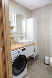 a bathroom with a washing machine and a sink at Modern Niidu Apartment in Pärnu +6 photos