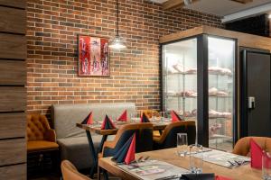 ヴェリングラードにあるSanté SPA Hotelのテーブルと椅子に赤いナプキンを乗せたレストランを併設しています。