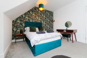 um quarto com uma cama azul e uma secretária em Carlton Hotel em Forres