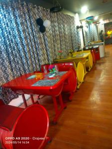 restauracja z czerwonym stołem i czerwonymi krzesłami w obiekcie Hotel 27 degree w mieście Dhanbad