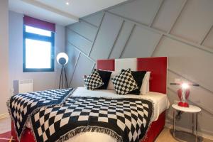 a bedroom with a large bed with black and white pillows at PALM TREE HOUSE - DINER in Orpington
