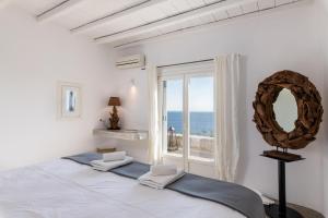 um quarto com uma cama com um espelho e uma janela em Villa Ava Mykonos em Míconos