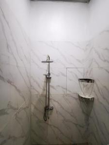 a white marble bathroom with a cross on the wall at LOBLUS (Low Budget Luxury Stay) in Padang