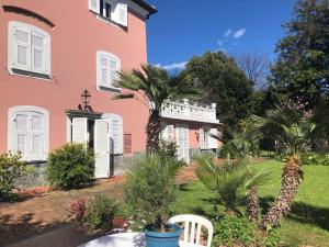a pink house with a palm tree in front of it at Villa Agostina in Vesima