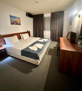 Habitación de hotel con cama con escritorio y ordenador en Brilliance, en Varna