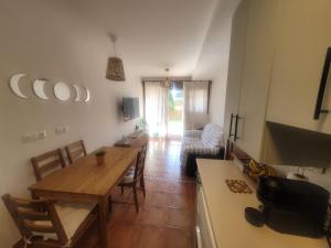 a kitchen and living room with a table and a dining room at Precioso Bajo con Jardin y Parking in Miengo