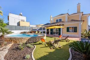 a backyard with a swimming pool and a house at Villa Tucha in Alvor