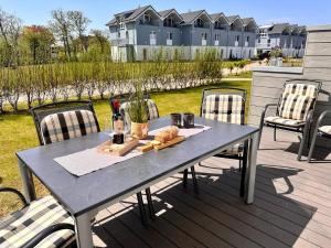 einen Tisch mit einem Teller Essen auf einer Terrasse in der Unterkunft Haus Nr 18, Ferienhaus Fischerhus in Wangerland