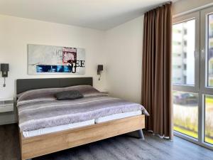 ein Schlafzimmer mit einem Bett und einem großen Fenster in der Unterkunft Haus Nr 18, Ferienhaus Fischerhus in Wangerland