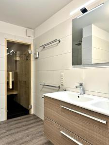 ein Badezimmer mit Waschbecken und Spiegel in der Unterkunft Haus Nr 18, Ferienhaus Fischerhus in Wangerland + 27 Fotos