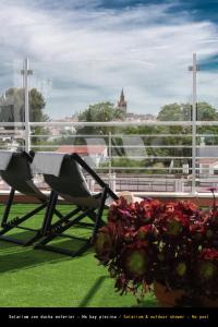 a balcony with a chair and a bouquet of flowers at Hotel Plaza Santa Lucía in Seville