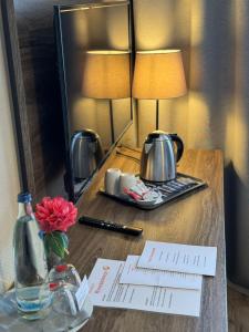 una mesa con espejo y un hervidor de agua. en Hotel Rahserhof, en Viersen