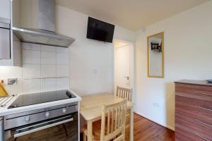 a kitchen with a table and a small kitchen with a stove at studio 69 in London
