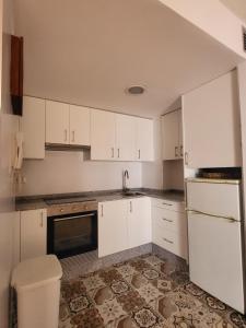 バレンシアにあるSingular Apartments Jorge Juanの白いキャビネットとシンク付きの空のキッチン