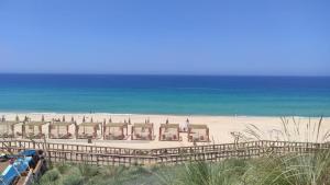 uma vista para uma praia com um resort e o oceano em Cabanas de Melides em Melides