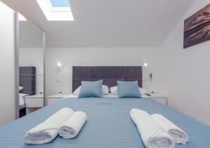 een slaapkamer met een blauw bed en handdoeken bij Villa Izvor in Bribir