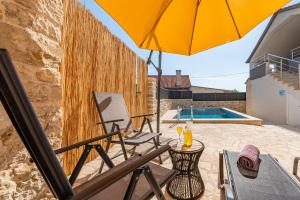 patio con tavolo, ombrellone e piscina di Villa Izvor ZadarVillas a Bribir