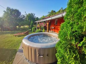 a hot tub in a garden next to a house at Holiday Home La Sierra in Korenica