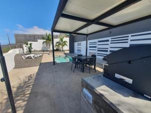 un patio avec une table et des chaises et une piscine dans l'établissement Villa Puesta de Luna, à Tazacorte