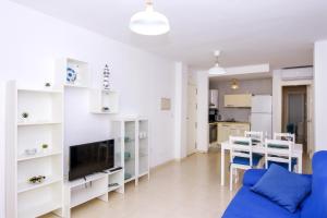 a living room with a blue couch and a table at La Puntica in Carboneras