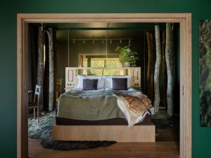 een slaapkamer met een groot bed in een groene kamer bij Eriksberg Hotel & Nature Reserve in Trensum