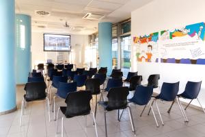 Habitación de clase con sillas y pantalla de proyección en Hotel Campus Sanpaolo en Turín