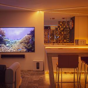 a living room with a bar and a large screen tv at Luxury Studio - Manchester City Centre in Manchester