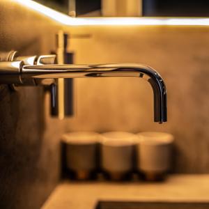 a close up of a faucet in a public bathroom at Luxury Studio - Manchester City Centre in Manchester +12 photos