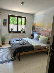a bedroom with a large bed with a painting on the wall at Gasthof Ostwind - ferienwohnungen & meer in Steffenshagen