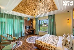 a bedroom with a bed and a table and a window at StayVista at Gauhar with Projector Set-up, Steam Room & Indoor Jacuzzi in Srinagar