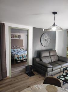 sala de estar con sofá y reloj en la pared en F2 EXTERIEUR LIT KING SIZE, en Brives-Charensac