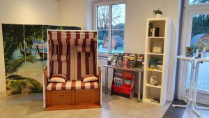 a room with a chair and a book shelf at 45 Camping Pod in Silberstedt