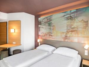 - une chambre avec un lit et une peinture murale dans l'établissement B&B Hotel Hamburg-Airport, à Hambourg