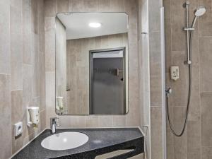 a bathroom with a sink and a shower at B&B Hotel Hamburg-Airport in Hamburg