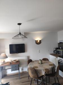 jadalnia ze stołem i krzesłami oraz kuchnia w obiekcie F2 EXTERIEUR LIT KING SIZE w mieście Brives-Charensac