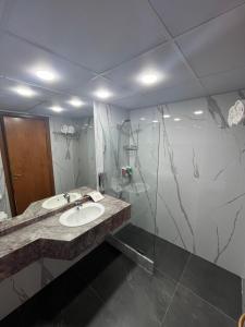 uma casa de banho com um lavatório e um chuveiro em El Sheikh Suites Hotel em Beirute