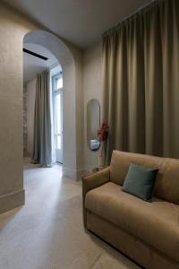 un soggiorno con divano e specchio di Palazzo Bellezia Luxury Suites a Torino