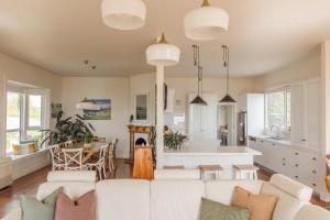 ein Wohnzimmer mit einem weißen Sofa und einer Küche in der Unterkunft 'THE FIRS' - Luxuriate with panoramic ocean views in Somerset