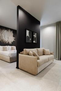 un soggiorno con divano e 2 letti di Palazzo Bellezia Luxury Suites a Torino
