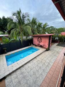 - une piscine à côté d'une maison avec des palmiers dans l'établissement CASA FOTR LOCO, à Uvita