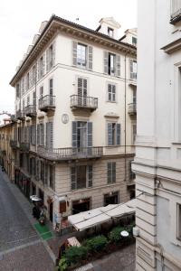 un grande edificio bianco con balconi su strada di Palazzo Bellezia Luxury Suites a Torino